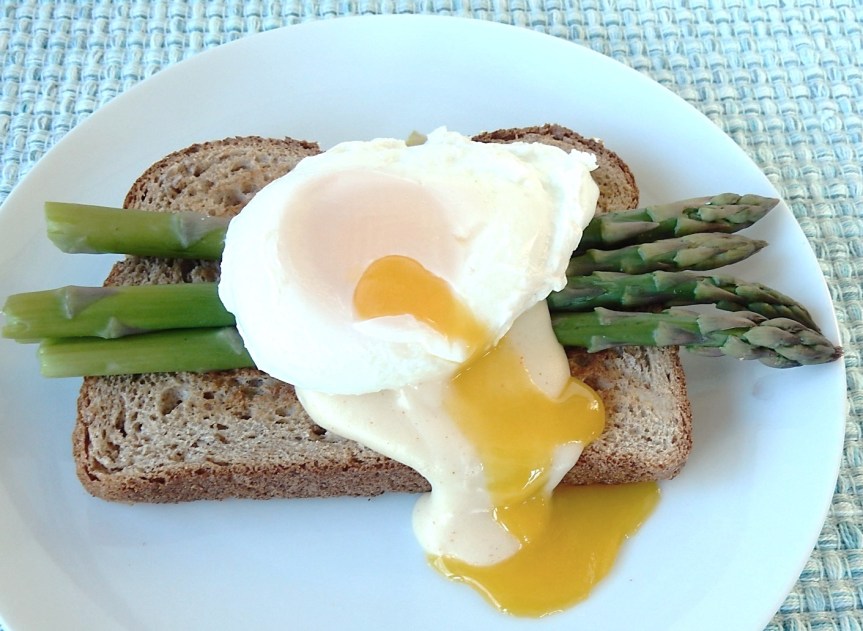 toast topped with asparagus, cheese sauce and poached egg