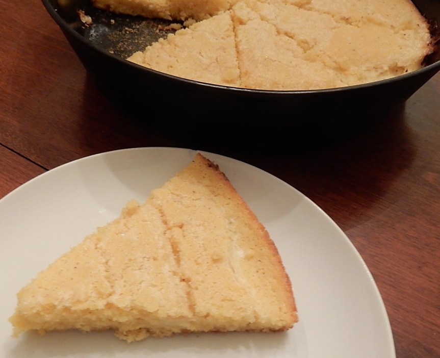 Piece of Spider Cornbread on plate with additional cornbread in background in skillet